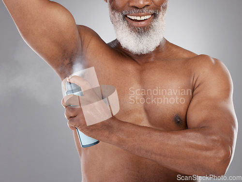 Image of Senior black man, deodorant and spraying armpit for personal hygiene, skincare or grooming against a gray studio background. Elderly African American male applying cosmetics for fresh or clean smell