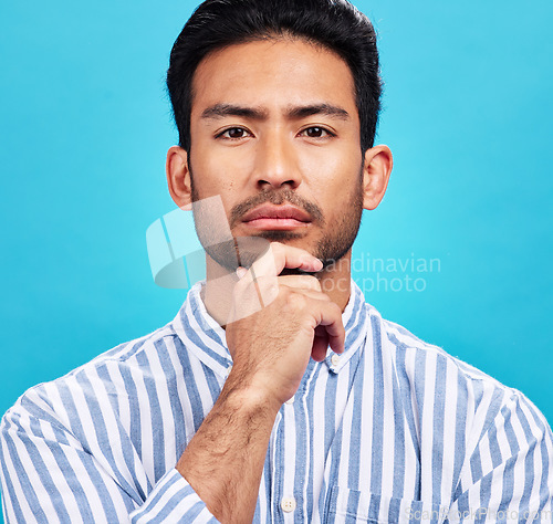 Image of Portrait of man on blue background, thinking and serious expression and hand on face isolated on studio backdrop. Confidence, mockup space and professional male model with pride and vision for future