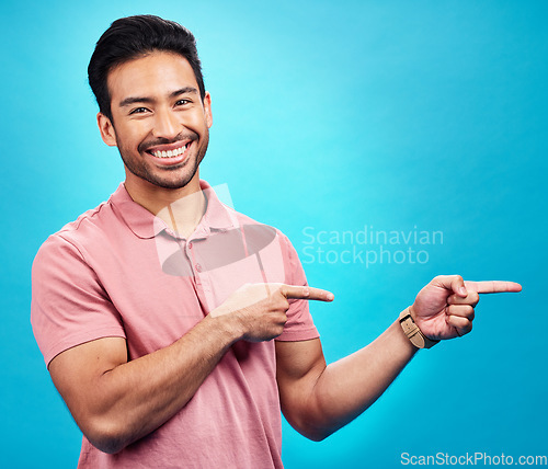 Image of Point, mockup and portrait of Asian man on blue background for news, information and announcement. Advertising, studio mockup and male pointing for branding copy space, promotion and show gesture