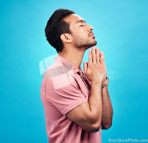 Image of Man is praying, religion and faith with worship to God, belief and spirituality isolated on blue background. Male person in prayer, Christian and gratitude with mindfulness and peace in studio