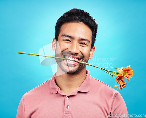 Image of Teeth, flower and portrait of man in studio for celebration, gift and romance. Funny, goofy and present with male isolated on blue background for happiness, smile and valentines day mockup