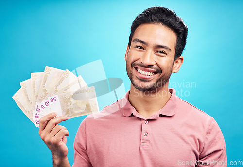 Image of Happy man in portrait, money fan and cash prize with financial freedom and reward isolated on blue background. Finance, savings and investment payment, male person with economic success in studio