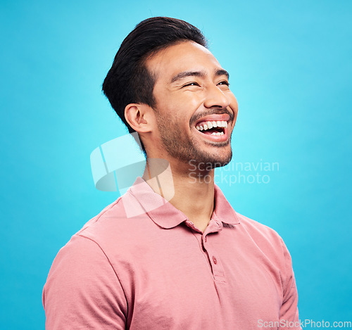Image of Funny comedy, laughter and man in studio isolated on a blue background. Comic, humor and Asian person laughing at joke, happiness and carefree for hilarious smile, excited and cheerful with emoji.