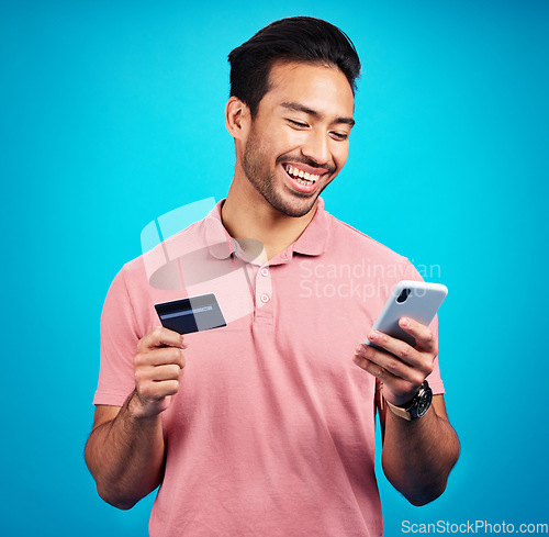 Image of Happy man with smartphone, credit card and smile, ecommerce and fintech isolated on blue background. Online shopping, internet banking and finance with technology and male with bank app on phone