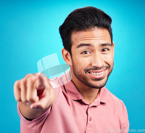 Image of Pointing, you and portrait of man. in studio for motivation, choice and decision. Happy, smile and yes with male and hand gesture isolated on blue background for option, offer and emoji mockup