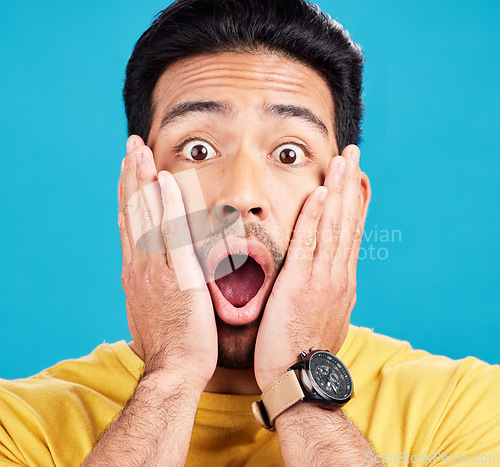 Image of Surprised, wow and portrait of shocked man face or emoji reaction to an announcement isolated in a blue studio background. OMG, fake news and male model with amazed facial expression in backdrop