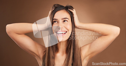 Image of Beauty, touch and woman with hair care, smile and confident lady against a brown studio background. Female, happy girl or person massage head, scalp and salon treatment with happiness, glow and shine