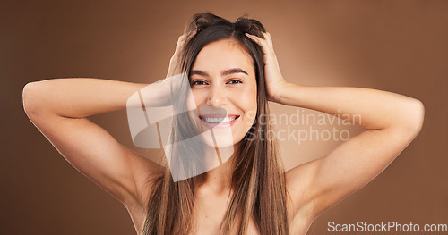 Image of Beauty, portrait and woman with hair care, happiness and female against a brown studio background. Face, happy girl and person massage scalp, salon treatment and confidence with wellness and glow