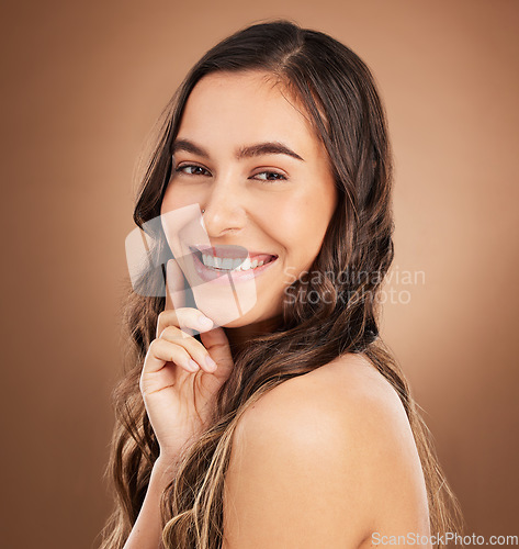 Image of Portrait, beauty and woman in studio for hair, treatment and cosmetics against a brown background. Haircare, face and girl smile for natural, curly or wavy, texture or keratin, textures and confident