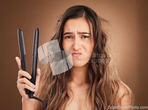 Image of Hair care, electric straightener and portrait of sad woman on studio background, worried face and dry salon hairstyle. Haircare damage, flat iron and frustrated latino model with spa heat treatment.