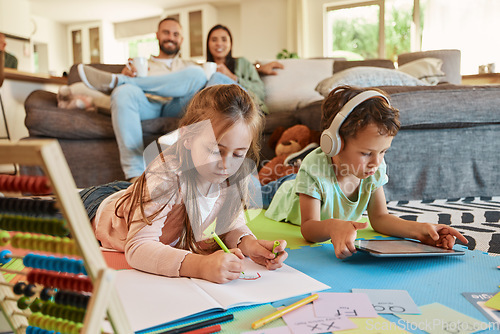 Image of Learning, floor and children with family relax on sofa for home writing, creative development and tablet. Kids on carpet on digital games, headphones and online education with happy parents on couch