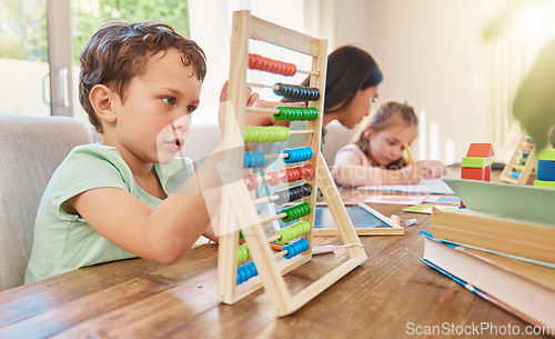 Image of Education, maths and a boy counting on an abacus while learning in the living room of his home. Children, homework and study with a male school kid in his house for growth or child development