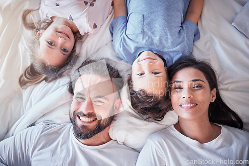 Image of Top view, smile and family on bed, love and bonding with quality time, break and relax together. Portrait, happy parents and mother with father, children and siblings in bedroom, happiness and peace
