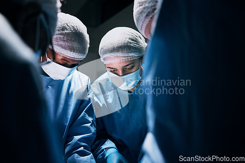 Image of Hospital, surgery and team of doctors in theatre for medical support, teamwork or healthcare solution in group. Focus of nurses and surgeon, face mask and working in operating room, emergency or help