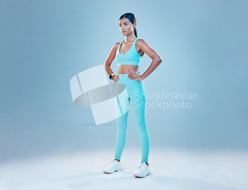 Image of Exercise, focus and mockup with a sports woman in studio on a blue background for health or wellness. Fitness, mindset and space with a young female athlete training for a healthy body or lifestyle