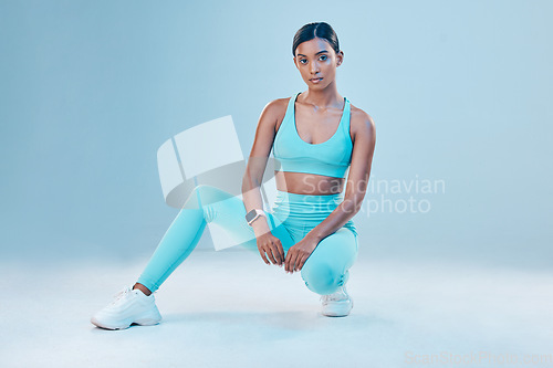 Image of Fitness, portrait and focus with a sports woman in studio on a blue background for health or wellness. Exercise, mindset and serious with a female athlete training for a healthy body or lifestyle