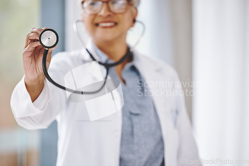 Image of Woman doctor, stethoscope and cardiologist in hospital for a heart health and wellness consultation. Professional female with healthcare or cardiology tool in hand for medical exam, checkup or care