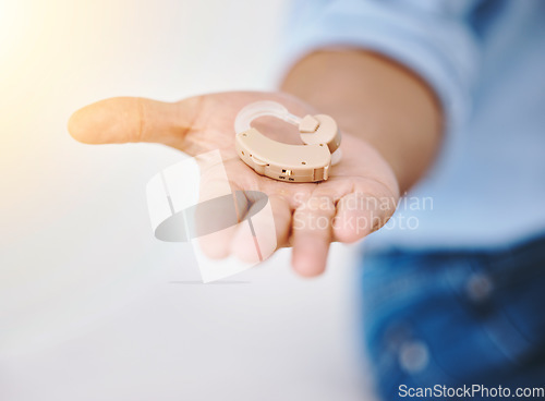 Image of Hearing aid, hands and person with disability for medical support, wellness and healthcare insurance. Closeup of deaf patient with audiology implant for sound waves, amplifier and help for listening