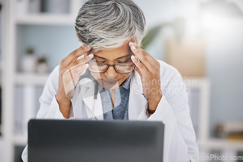 Image of Woman doctor, laptop and headache or stress from burnout in hospital office while working. Medical professional female with anxiety, mental health problem and depression from healthcare results