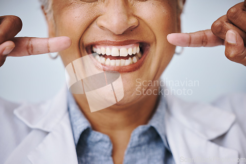 Image of Dental, hand and pointing by elderly woman in studio for mouth, hygiene or denture care on grey background. Teeth whitening, cleaning and senior lady happy for oral, tooth and natural looking veneers