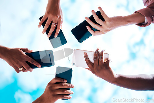 Image of Connection, below and hands with phone on a blue sky for social network, communication and sharing. Bluetooth, friends and group with mobile for an app share, cloud computing and circle networking