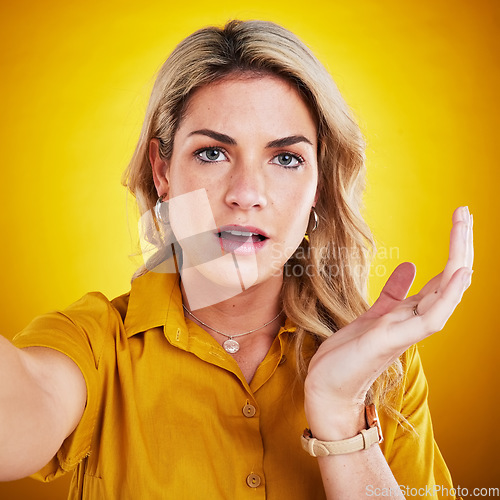 Image of Selfie, shock and portrait with a woman on the background of a yellow studio looking surprised. Face, photograph and what hand gesture of attractive female model feeling confused with awe expression