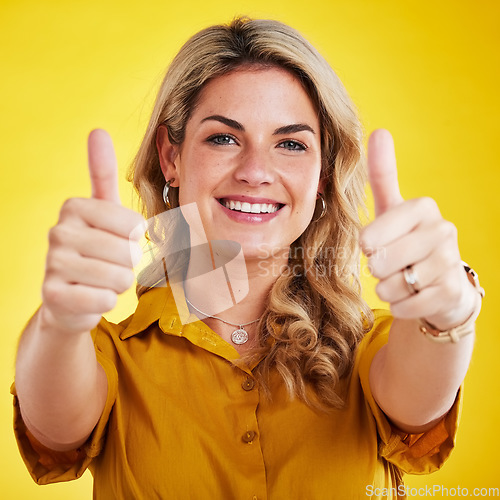 Image of Portrait, thumbs up and motivation with a woman on a yellow background in studio to say thank you. Face, hands and welcome with an attractive young female model indoors in gesture of emoji or support