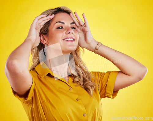 Image of Happy, thinking and a woman fixing hair isolated on a yellow background in a studio for grooming. Smile, idea and a young girl looking confident touching hairstyle for appearance and happiness