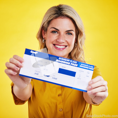 Image of Happy woman, plane ticket and portrait smile for travel, flight or vacation against a yellow studio background. Female traveler smiling with boarding pass, passport or permit for traveling or trip