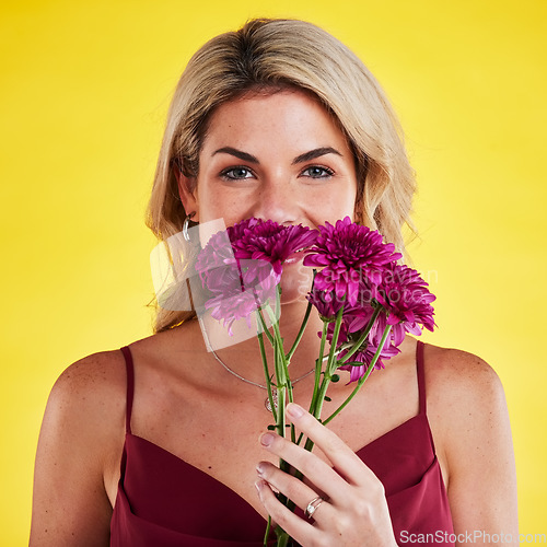 Image of Portrait, smell and woman with flowers, beauty and confident girl against a studio background. Face, female person and model with plants, natural care and floral present with lady, bouquet and scent