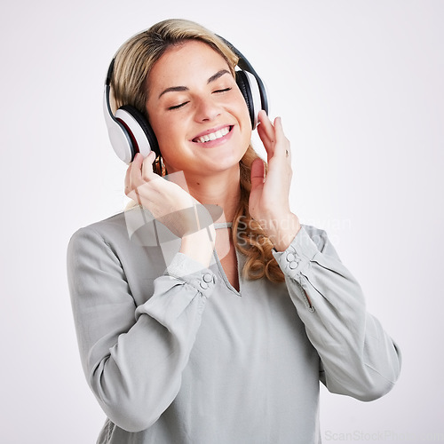 Image of Music, smile and happy woman in studio with headphones for audio track on grey background. Radio, relax and excited female with earphones for podcast, playlist and online, streaming and subscription