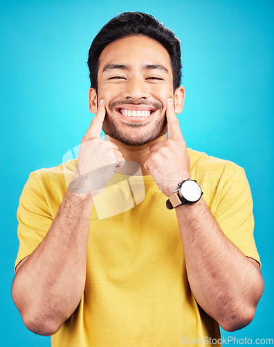 Image of Happy, smile expression and portrait of a man expressing happiness, joy and cheerful face. Young, confident and a person smiling for positivity and confidence isolated on a blue background in studio