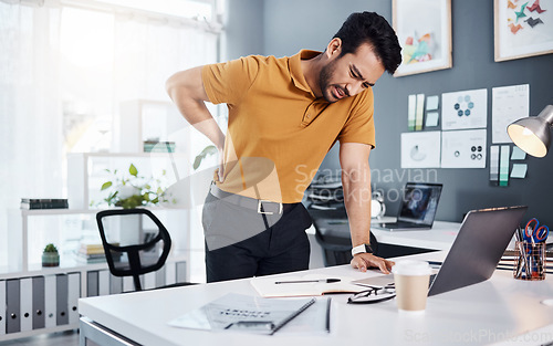 Image of Business man, stress and back pain at office desk with a injury and issue. Asian male entrepreneur with technology and frustrated with body ache, mental health or burnout problem while tired