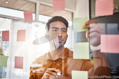 Image of Planning, writing and focused man on glass for project management, workflow and business schedule. Asian person brainstorming ideas, moodboard and sticky notes for solution, reminder or job priority