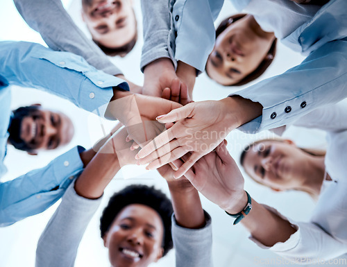 Image of Business people, hands stack and teamwork in low angle, team building and trust. Solidarity, huddle and happy group or staff of men and women with hand together for motivation, synergy and support.