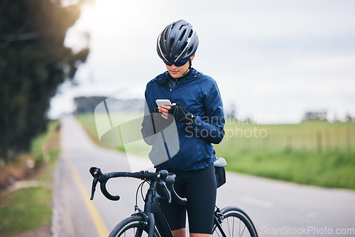 Image of Woman, bicycle athlete and outdoor with phone for social media technology, mobile app or search gps direction. Female cyclist, bike and typing on smartphone for network notification, sport or cycling