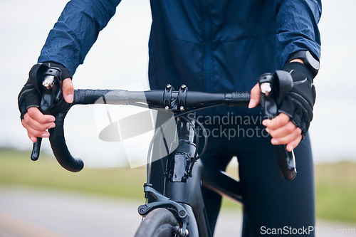 Image of Hands of person, athlete and bicycle handlebar for training, triathlon sports and cardio fitness. Closeup, bike gear and cyclist holding lever, brakes and cycling outdoor for action, race and journey