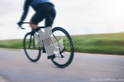 Image of Person, bicycle athlete and cycling on motion blur in nature, countryside and training for triathlon from behind. Cyclist, mountain bike and speed on road for sports, power or cardio competition race