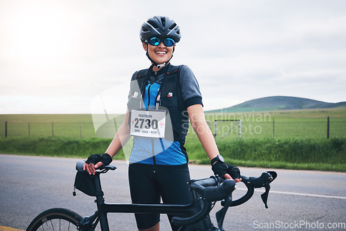 Image of Portrait, cycling or happy woman in nature with bicycle for exercise, workout or training for triathlon fitness. Girl cyclist, sports or biker on break exercising for cardio endurance with smile