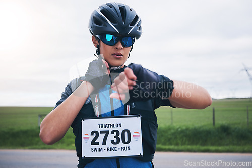 Image of Woman, cyclist and check heart rate on watch, timer and monitor health progress in triathlon race. Female bicycle athlete, neck pulse and stopwatch for cycling performance, cardio training and sports