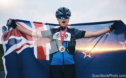 Image of Winner sports, happy woman and flag with gold medal for winning outdoor cycling race or New Zealand triathlon. Happiness, win and success cyclist in wow, fitness and world record with national pride.