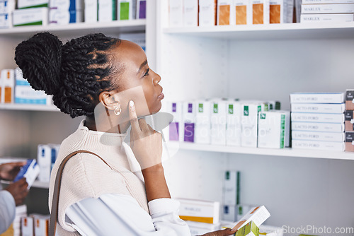 Image of Black woman, patient and thinking for healthcare drugs, medication decision for pain relief on pharmacy shelf. Thoughtful African female customer looking at pharmaceutical products for self diagnosis