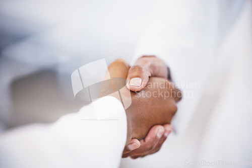 Image of Doctor, handshake and meeting in thank you for agreement, deal or healthcare at hospital. Medical professional shaking hands with patient for healthy wellness, consultation or partnership at clinic