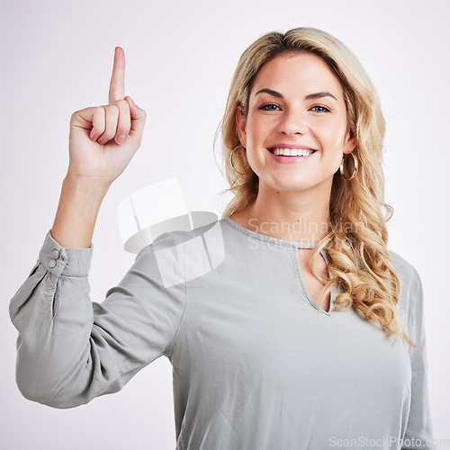 Image of Woman, portrait and pointing finger up with a smile for hope, religion and God isolated on a white background. Female person with a hand gesture for direction, happiness and presentation in studio