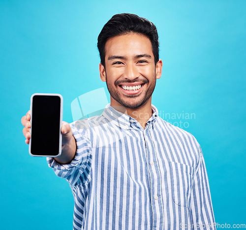Image of Phone screen, mockup and portrait of man isolated on blue background for mobile app or advertising space. Happy face of asian person with cellphone mock up for website, contact or ux design in studio