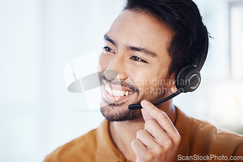 Image of Asian man, call center and smile with headphones for customer service, consulting or support at office. Happy male consultant or agent smiling in telemarketing with headset for online advice or help