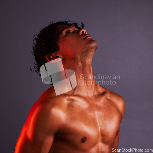 Image of Body, beauty and man profile in a studio with art lighting and thinking with muscles and fitness. Focus, isolated and gray background of an attractive male model with artistic, light and wellness