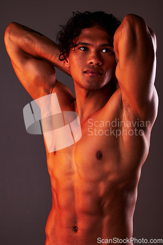 Image of Man, sexy and torso body in studio for art, fitness or beauty of a person on a dark background. Face, strong muscle and male model with a six pack, glow and creative motivation for aesthetic backdrop