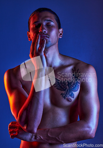 Image of Sexy, beauty and man in dark light with chest tattoo as body art and model isolated in a studio background closed eyes. Creative, topless and young artistic person with seductive look in a shadow