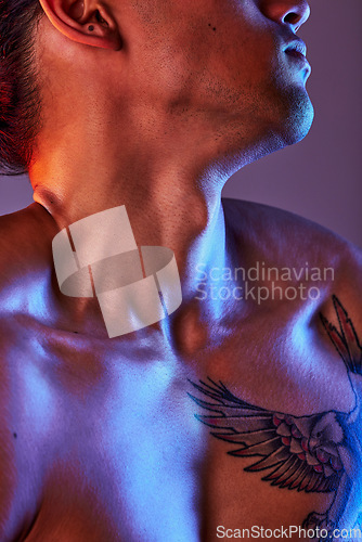 Image of Man, chest and neon light in studio for art, fitness or beauty of a person on a gray background. Strong body, neck and male model with a tattoo, glow and creative motivation for aesthetic backdrop